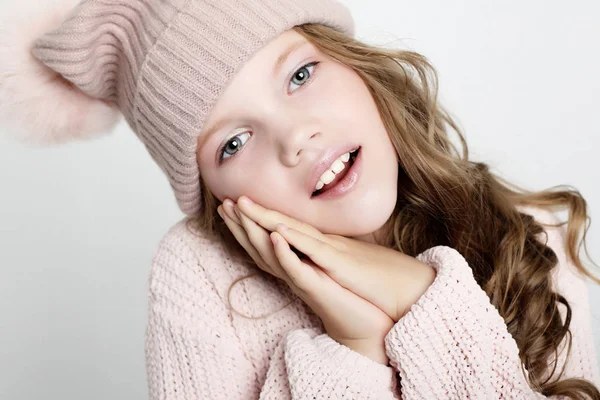People, childhood and fashion concept: little girl child wearing pink winter hat and sweater over pink background — Stock Photo, Image