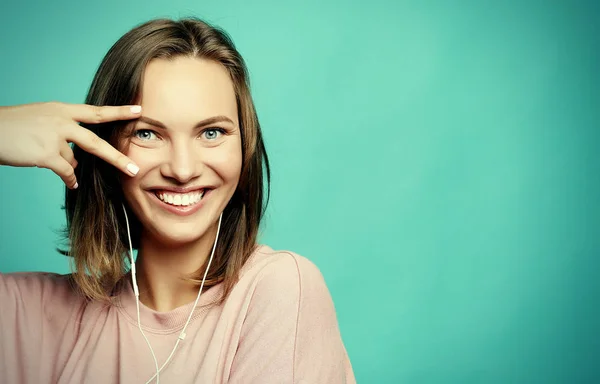 Retrato de mujer hermosa mirando a la cámara con sonrisa y mostrando signo de paz con los dedos —  Fotos de Stock