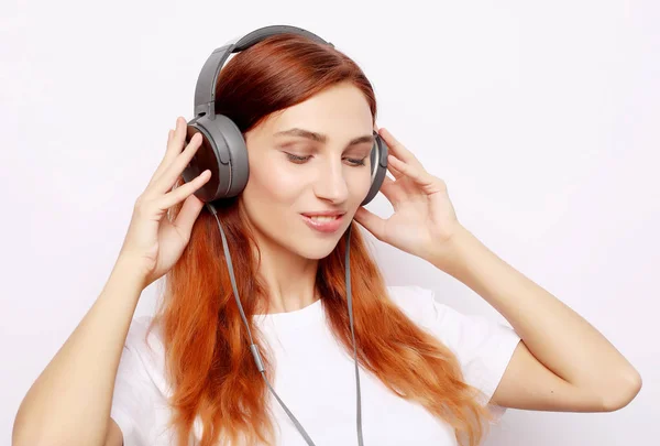 Hermosa pelirroja mujer en auriculares escuchando música —  Fotos de Stock