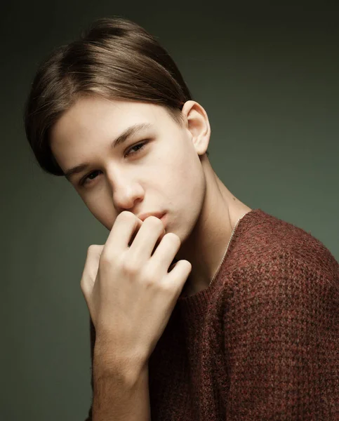 Attractive teenage boy posing in studio over grey background — Stock Photo, Image