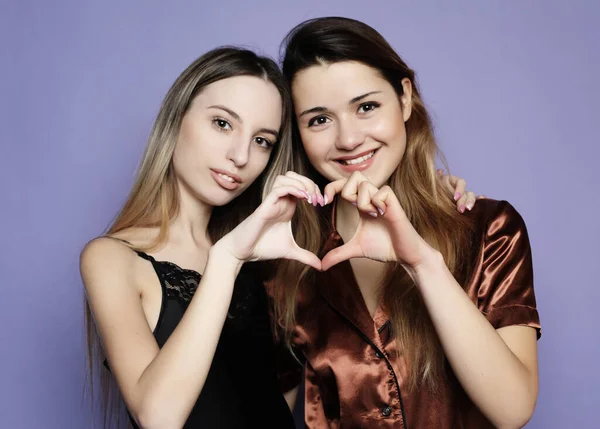 Stile di vita e il concetto di persone: due belle ragazze vestite in pigiama abbracciare e prendere selfie — Foto Stock