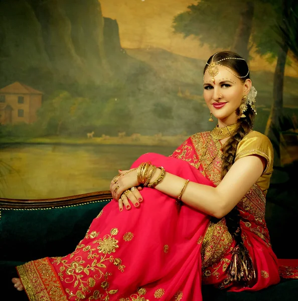 Portret uśmiechnięty pięknej hinduskiej dziewczyny w domu. Młoda kobieta model ze złotą biżuterią zestaw . — Zdjęcie stockowe