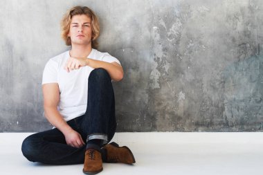 Stüdyoda poz veren yakışıklı genç bir erkek, moda tarzı.