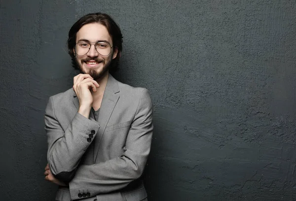 Jovem bonito homem posando no fundo da parede cinza — Fotografia de Stock