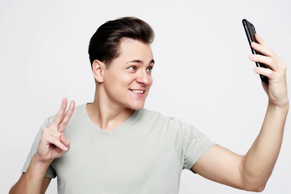 Foto de un hombre guapo sonriendo en la cámara tomando selfie — Foto de Stock