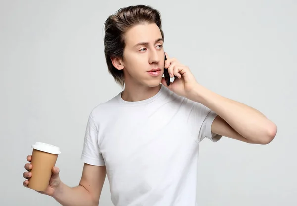 Portret van een gelukkige man die telefoneert en koffie drinkt — Stockfoto