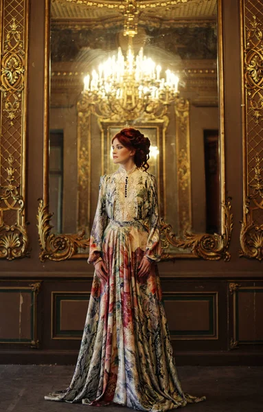 Hermosa mujer de pie en la habitación del palacio con espejo . — Foto de Stock