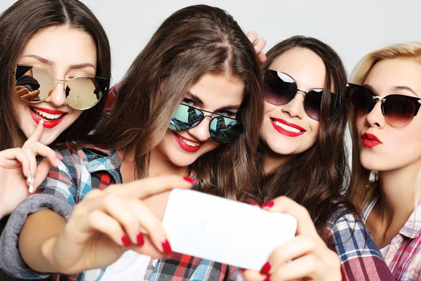 Cuatro chicas adolescentes felices con teléfono inteligente tomando selfie —  Fotos de Stock