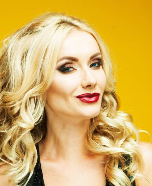 Kıvırcık sarı saçlı, çekici görünüşlü, şehvetli dudaklı, manken gibi çekici bir kadın.