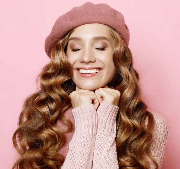 Schöne junge weibliche Modell mit langen welligen Haaren trägt rosa Baskenmütze und Schal — Stockfoto