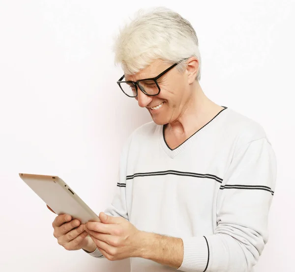 Стиль жизни, технологии и концепция людей: счастливый пожилой человек с помощью цифрового планшета . — стоковое фото