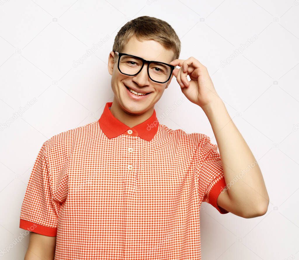 Portrait of a smart young man wearing eyeglasses standing against white background