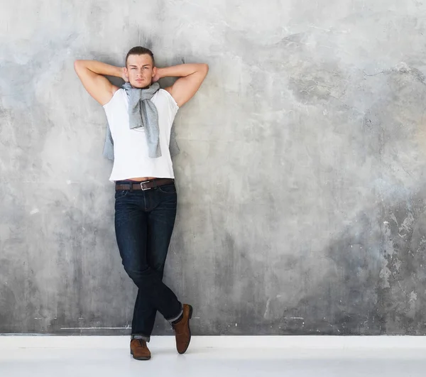 Hombre, modelo de moda posando en camiseta blanca en jeans en longitud completa —  Fotos de Stock