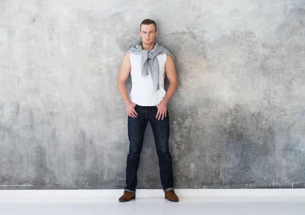 Мужчина, модель позирует в белой футболке в джинсах в полный рост — стоковое фото