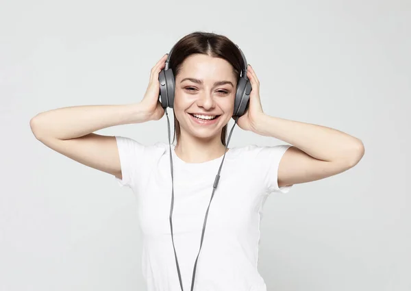 Estilo de vida y el concepto de la gente: mujer joven con auriculares escuchando música. —  Fotos de Stock