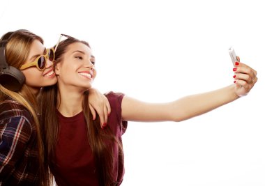 Hippi kıyafetli iki genç kız telefonda selfie çekiyor..