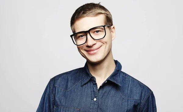 Retrato de un joven inteligente con anteojos parados sobre fondo blanco — Foto de Stock