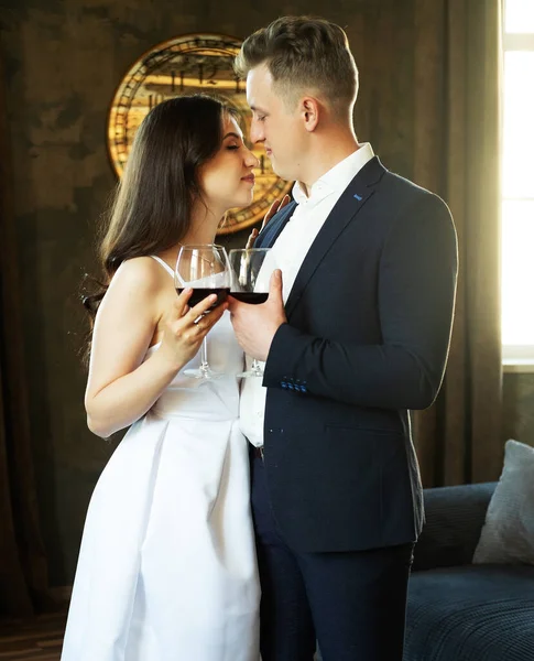 A fiatal házaspár bort iszik és mosolyog boldogságukra, romantikájukra és gyengédségükre. — Stock Fotó