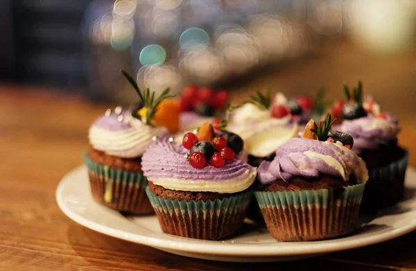 Vários cupcakes com bagas frescas - groselhas e mirtilos, close-up — Fotografia de Stock