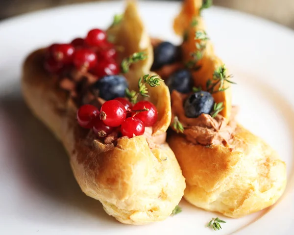 Traditionelle französische Eclairs auf weißem Teller in Nahaufnahme — Stockfoto