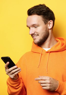Tehnoloji ve insanlar konsepti - cep telefonlu genç adam, arkadaşlarıyla konuşuyor