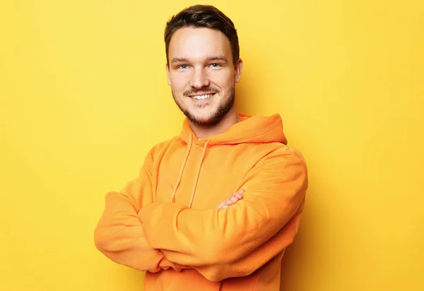 Ung leende man står mot gul bakgrund — Stockfoto