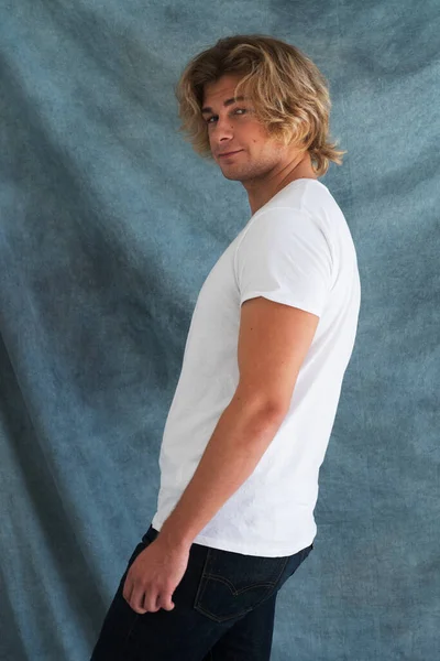 Handsome young man in blank white shirt posing in studio, fashion concept — Stock Photo, Image