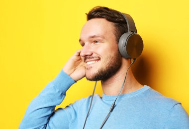 Sarı arka planda müziğe lisanslı yakışıklı adam
