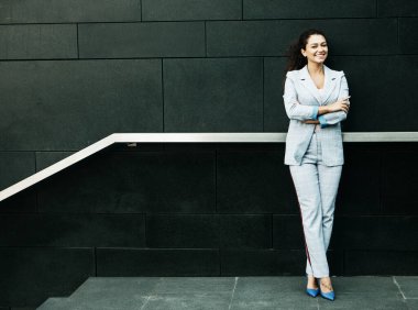 İş tarzı giyinmiş afro kadın merdivenlerin yanında, iş ve kariyer konsepti.