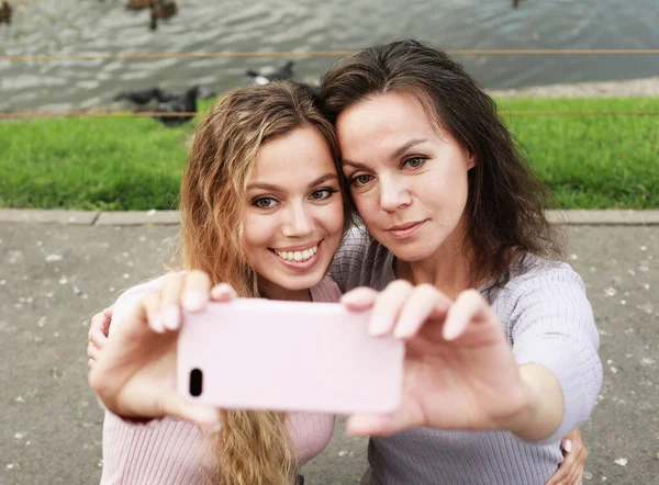 Maduro mãe e filha adulta estão fazendo selfie por telefone celular no parque de verão — Fotografia de Stock