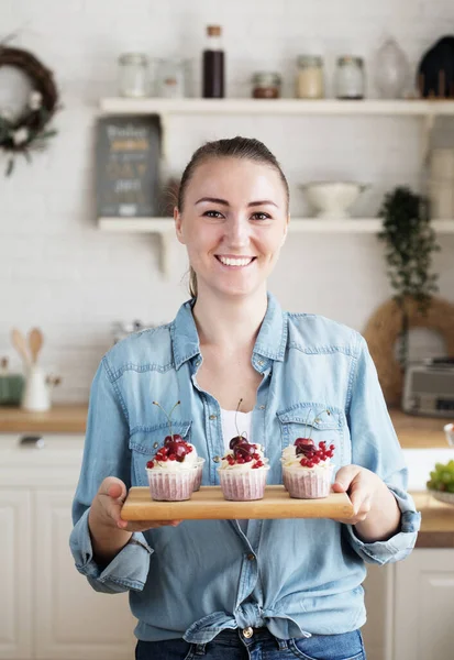 Young baker woman holding cupcakes. Happy, smiling and cheerful. — Stock Photo, Image