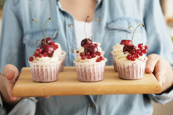 Jovem padeira segurando cupcakes. Feliz, sorridente e alegre. — Fotografia de Stock