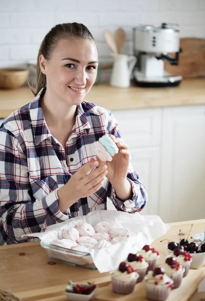 Beautiful woman pastry chef makes sweet cakes in kitchen — Stock Photo, Image