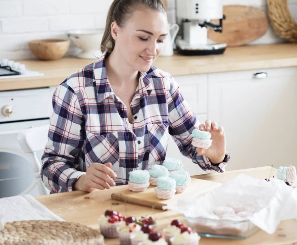 Hermosa mujer pastelera hace pasteles dulces en la cocina — Foto de Stock