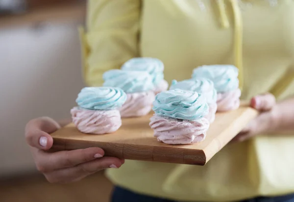 Giovane pasticciera che tiene in mano dei dolci. Felice, sorridente e allegro. — Foto Stock