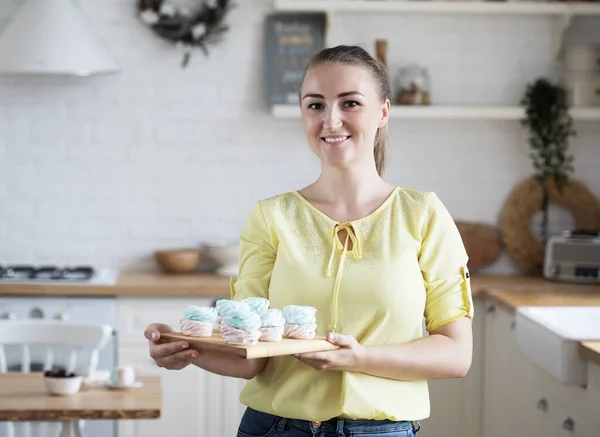 Young baker woman holding pastries. Happy, smiling and cheerful. — Stock Photo, Image