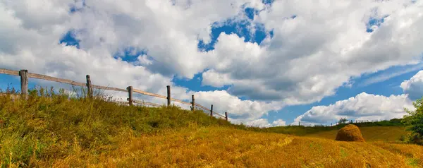 Fence and haycock on field panorama — Stock Photo, Image