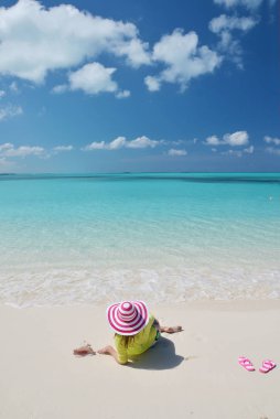 Güneş-şapkalı genç kadının fotoğrafını rahatla kumlu plaj, Büyük Exuma üzerinde Bahama Adaları