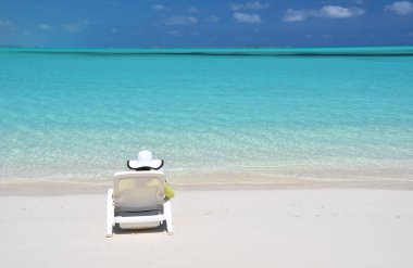 Güneş-şapkalı genç kadının fotoğrafını rahatla kumlu plaj, Büyük Exuma üzerinde Bahama Adaları