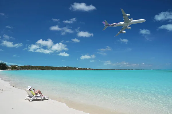 太阳帽上的年轻女子照片在大埃克苏马的沙滩上放松 巴哈马与飞机在蓝天上 — 图库照片