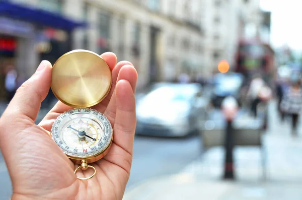 Compass in the hand against a city street — Stock Photo, Image