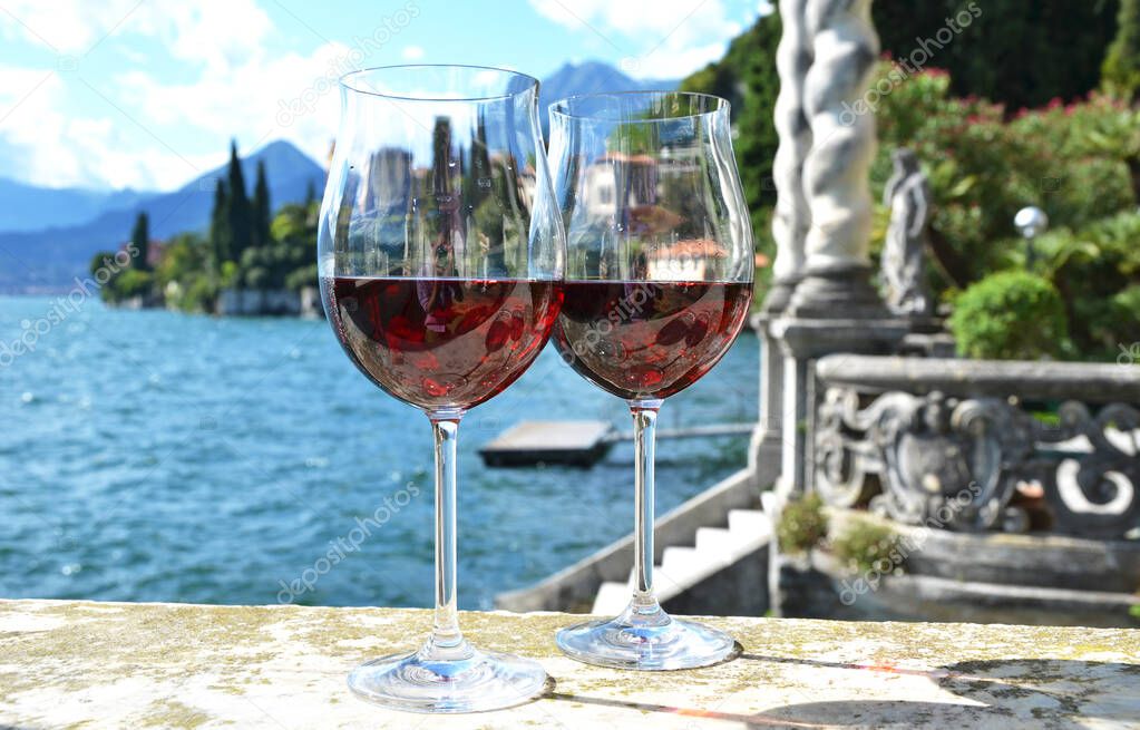 Two wine glasses against lake Como, Italy