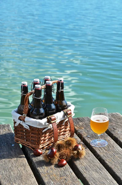 码头上的啤酒瓶和栗子 免版税图库照片
