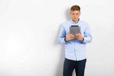 Yukarıya bakıp beyaz duvara karşı duran genç adam.