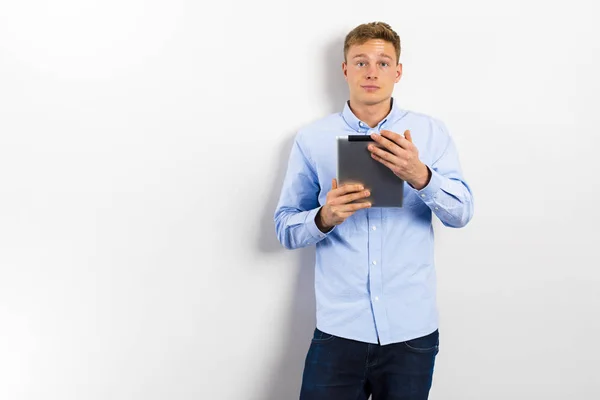 Junger Mann Blickt Auf Und Steht Vor Weißer Wand — Stockfoto