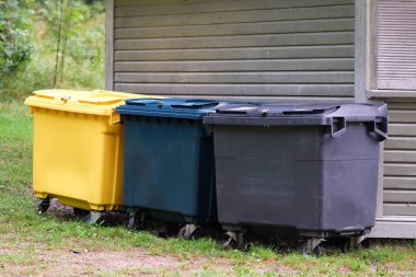 Duvarda üç tane çöp konteynırı