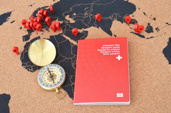 Swiss passport and compass on the pinboard map
