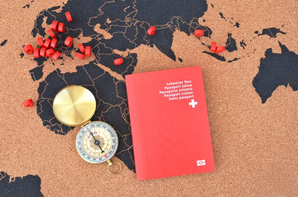 Swiss passport and compass on the pinboard map