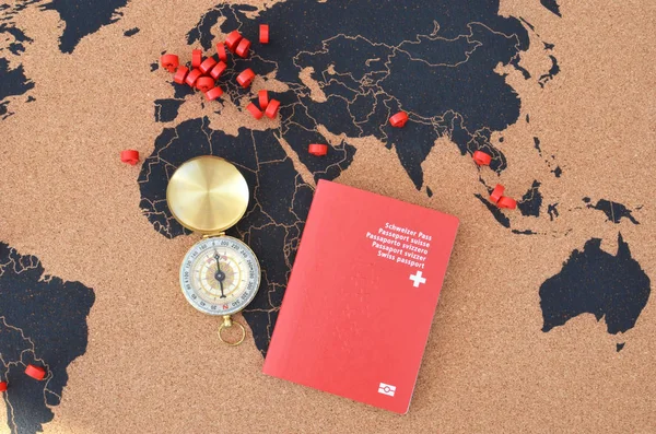 Swiss passport and compass on the pinboard map