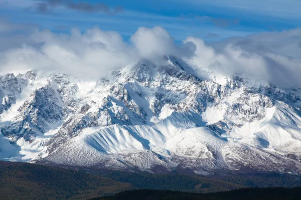 アルタイ山脈北の雪に覆われた斜面 Chuysky尾根 山頂は白い雲に覆われている ロイヤリティフリーのストック画像